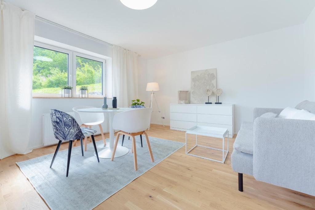 una sala de estar blanca con mesa y sillas en Perfektes Appartement für Erholung in der Wachau!!, en Spitz