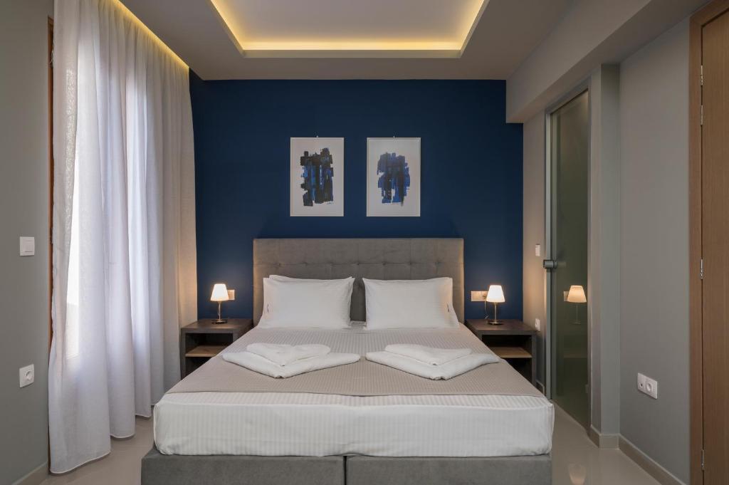 1 Schlafzimmer mit blauen Wänden und 1 Bett mit 2 Kissen in der Unterkunft MIRMA CITY Old Town in Chania