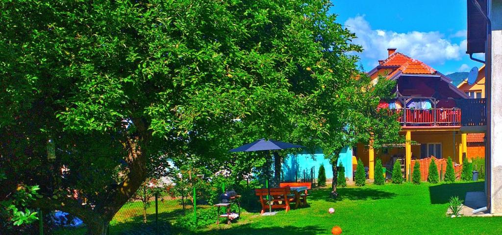 a house with a yard with a table and an umbrella at Guest house Dagovic in Bajina Bašta