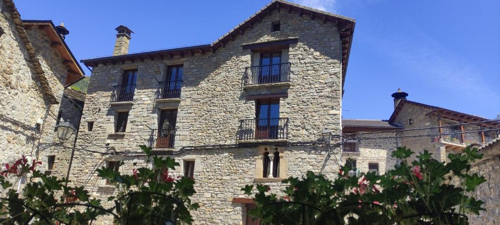 a large stone building with windows and a tower at Apartamento Miguel Torla Ordesa in Torla-Ordesa