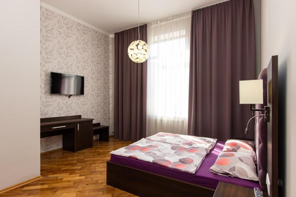 a bedroom with a bed and a desk in it at Апартаменти в центрі міста in Ivano-Frankivsk