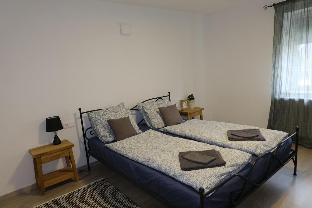 Un pat sau paturi într-o cameră la Kajári Apartmanház
