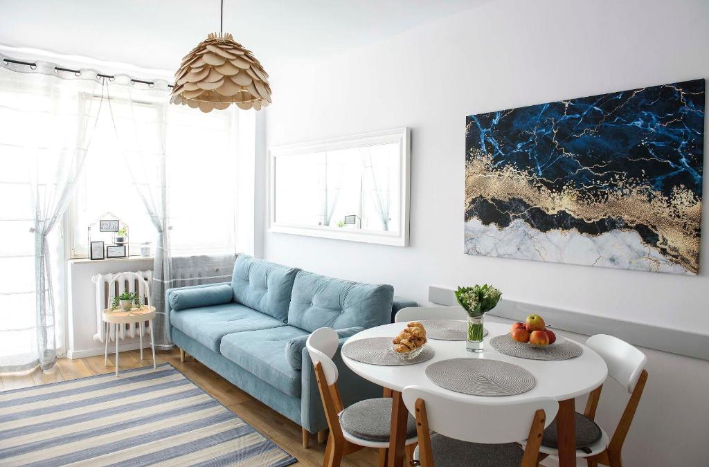 - un salon avec un canapé bleu et une table dans l'établissement Przy Brzegu - Hel studio, à Hel