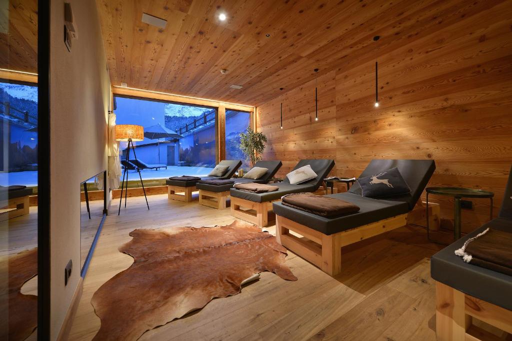 a living room with couches and a large tree stump at Hotel Astoria in Livigno