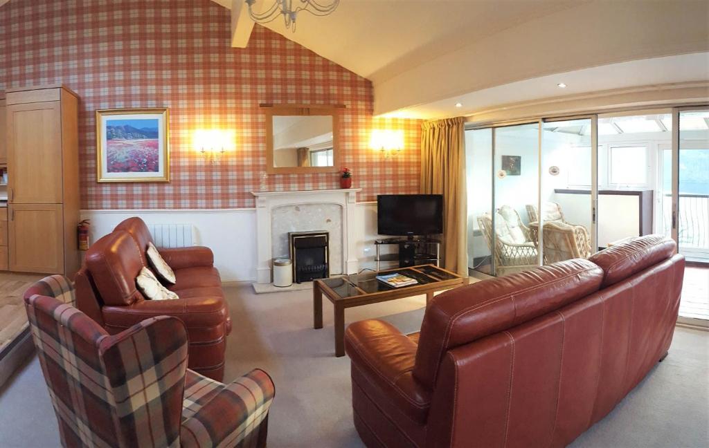 sala de estar con muebles de cuero y chimenea en Loch Rannoch Highland Lodge 44, en Kinloch Rannoch