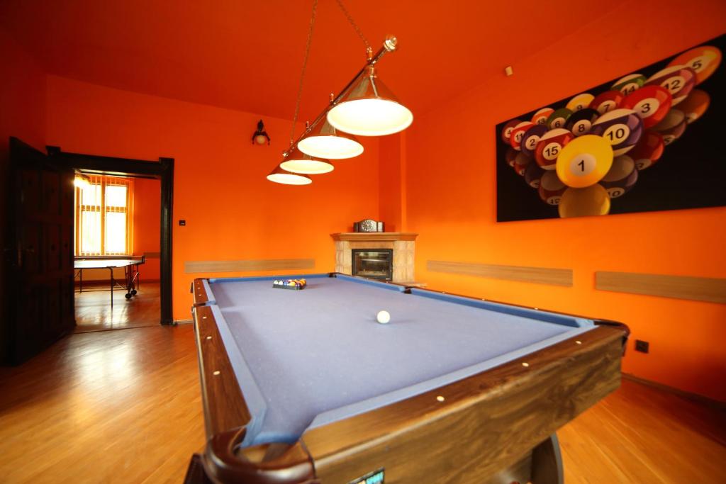 a pool table in a room with an orange wall at Leśny Dwór in Długopole-Zdrój