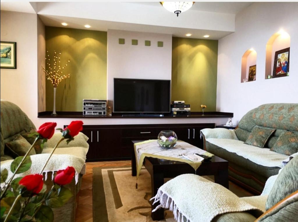 ein Wohnzimmer mit einem Sofa und einem TV in der Unterkunft Villa Stefan in Ohrid