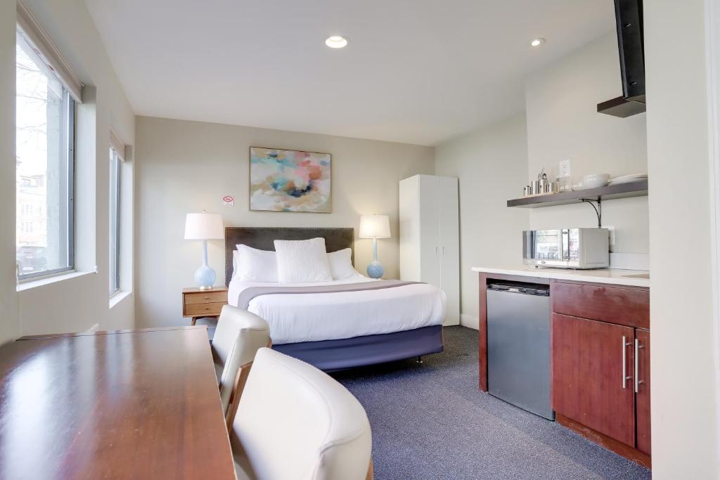 a hotel room with a bed and a kitchen at Sojourn at DuPont Place in Washington