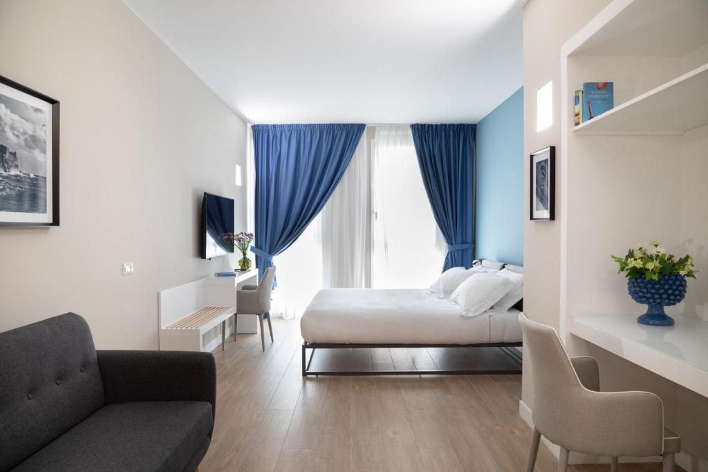 una camera d'albergo con letto e divano di Alma Suites a Napoli