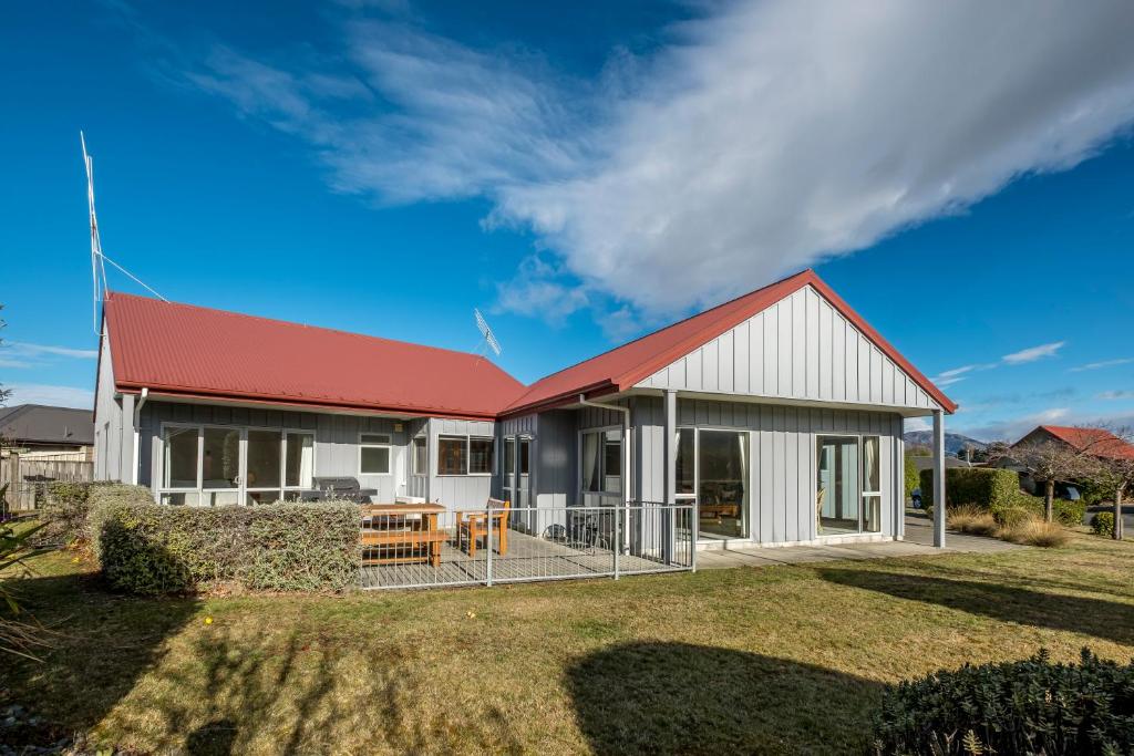 uma casa com um telhado vermelho e um quintal em 22 Tarndale Place em Hanmer Springs