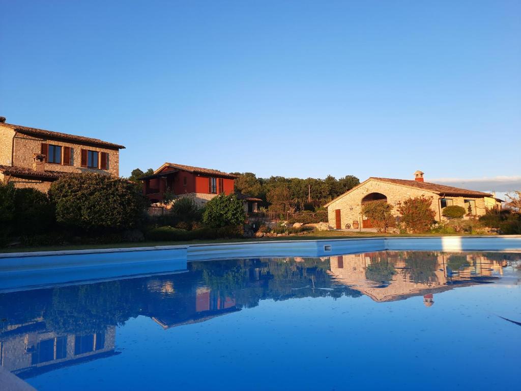 a pool of water in front of a house at Agriturismo Borgo Montecucco in Todi