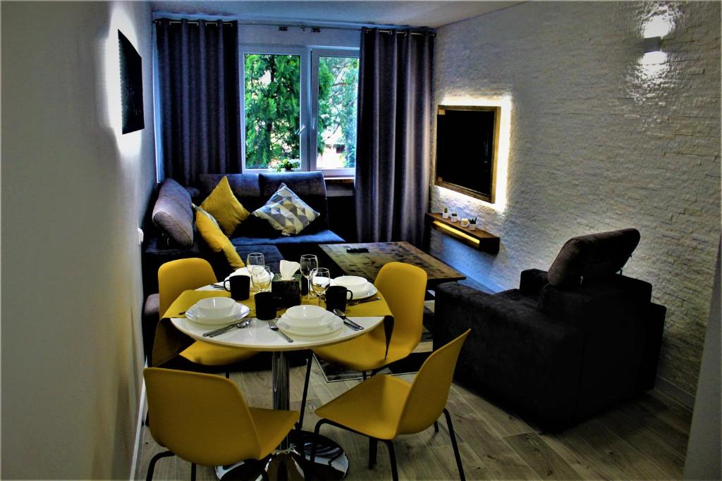 uma sala de estar com uma mesa e cadeiras amarelas em Apartament przy Arsenale em Breslávia