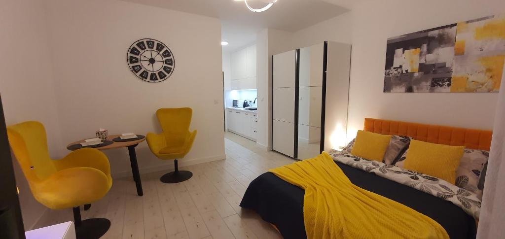 sypialnia z łóżkiem i 2 żółtymi krzesłami w obiekcie Apartament Dwa kroki do zatoki w mieście Puck