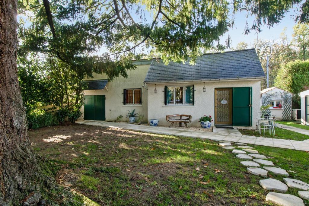una casa con una puerta verde y un patio en Maison d'une chambre avec jardin clos et wifi a Belloy en France, en Belloy-en-France