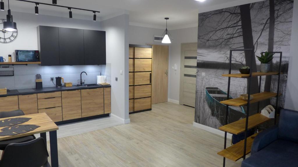 a kitchen and living room with a table and chairs at APARTAMENT PIOTR in Iława