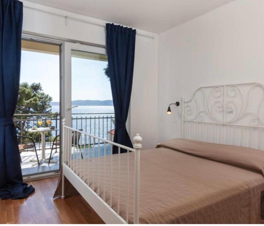 a bedroom with a bed and a balcony with a view at Villa Ima in Brela