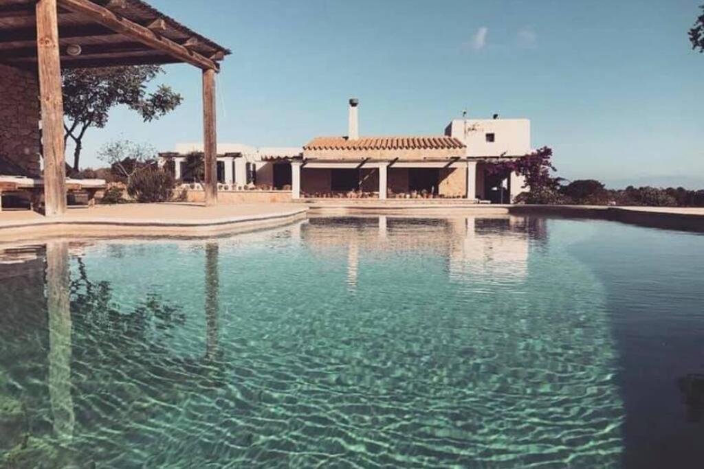a large pool of water in front of a house at Villa Casa Limón Formentera in Cala Saona