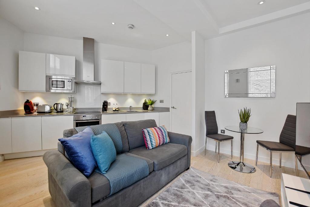 a living room with a couch and a kitchen at West Street by Q Apartments in London