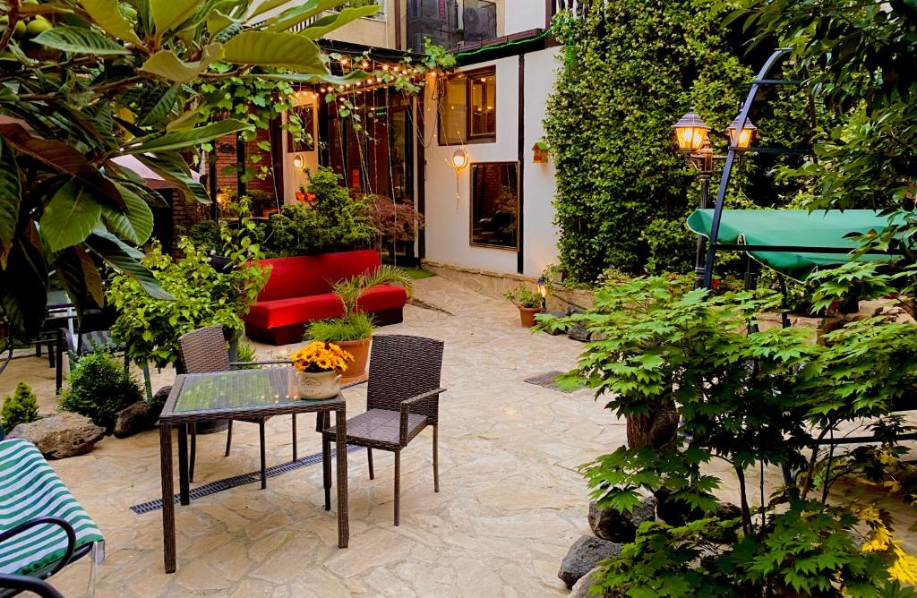 a patio with a table and chairs and a red couch at Elea Old Tbilisi Hotel in Tbilisi City