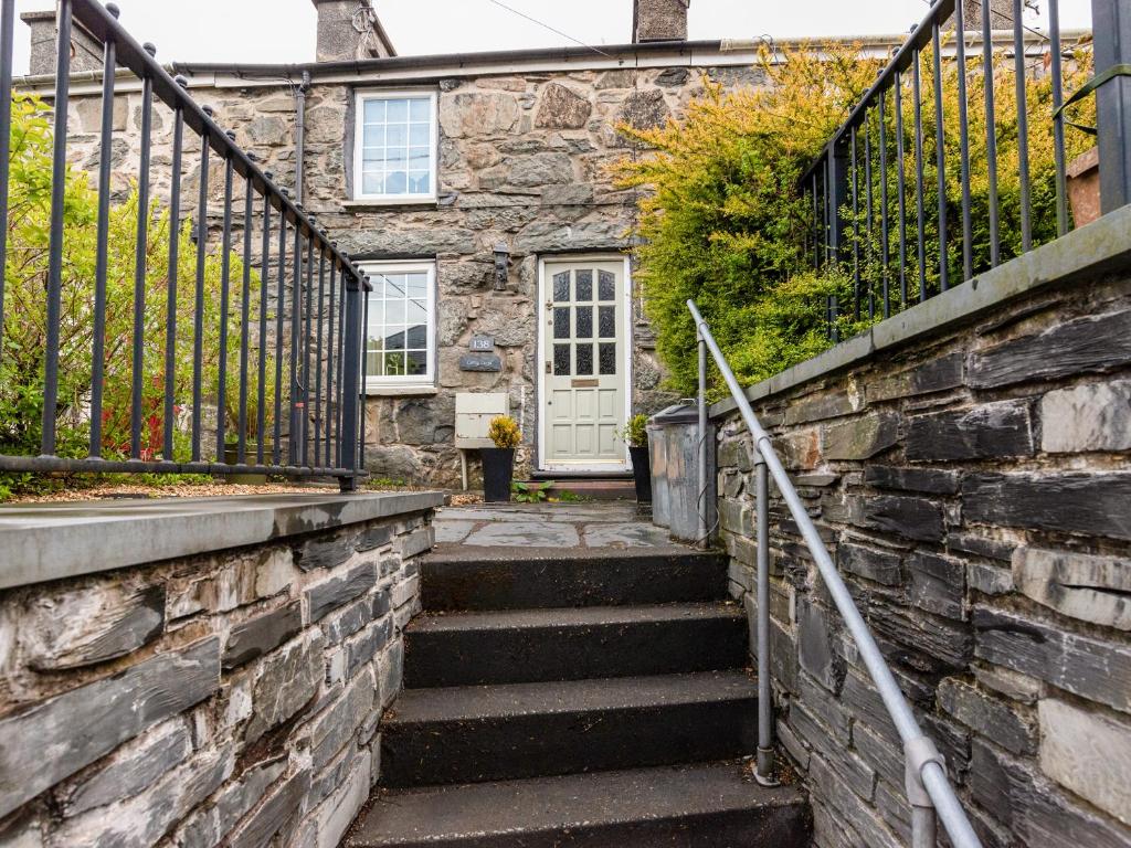 una casa de piedra con escaleras que conducen a una puerta en Carreg Lwyd, en Blaenau Ffestiniog