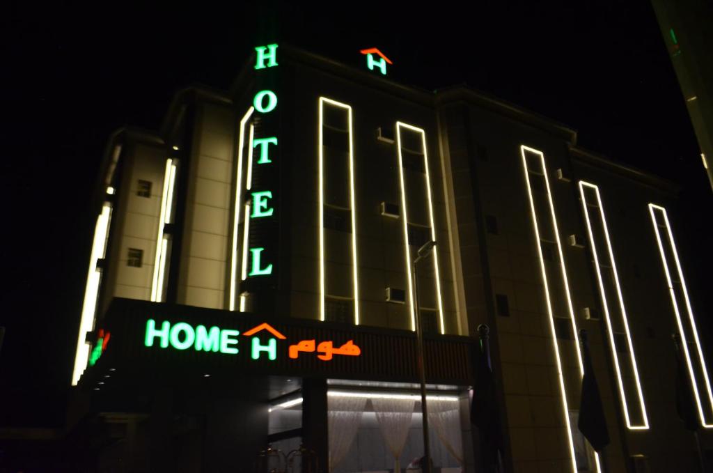 un cartello di fronte a un edificio con un cartello home theater di هوم للأجنحة الفندقية a Khamis Mushayt