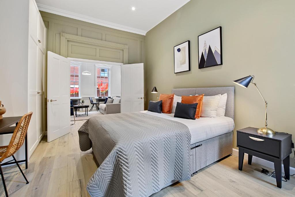 a bedroom with a bed and a table and chairs at GERRARD PLACE by Q Apartments in London