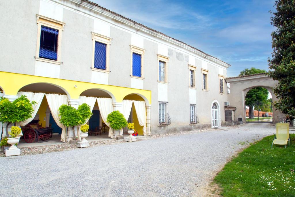 un grande edificio bianco con alberi di fronte di B&B VILLA VENGA a Desenzano del Garda