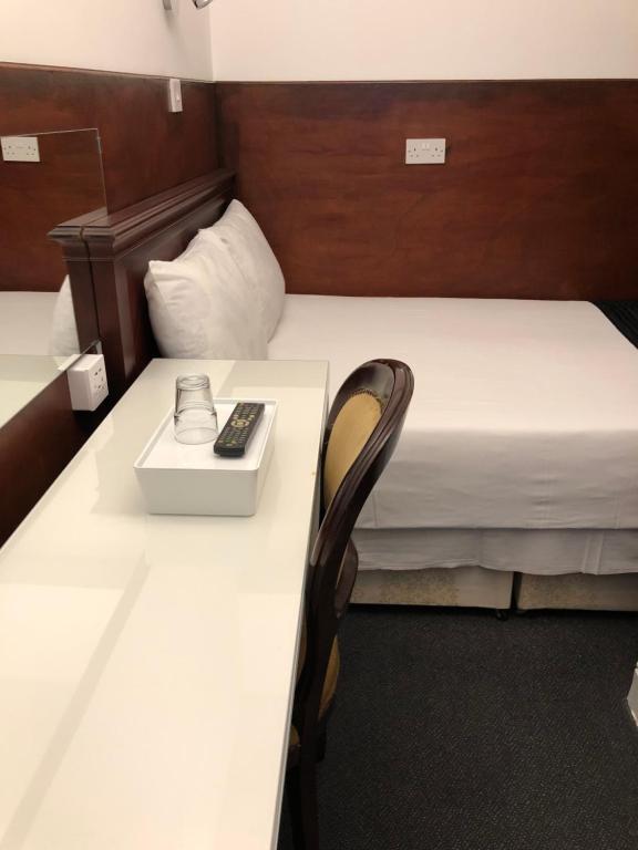 a hotel room with a bed and a desk at Plaza London Hotel in London