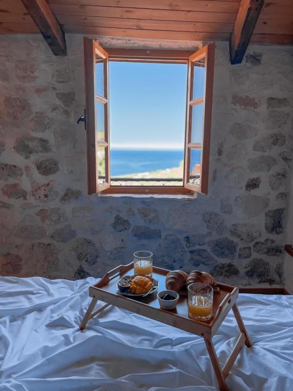 a tray of food sitting on a bed with a window at Roots Dhermi in Dhërmi