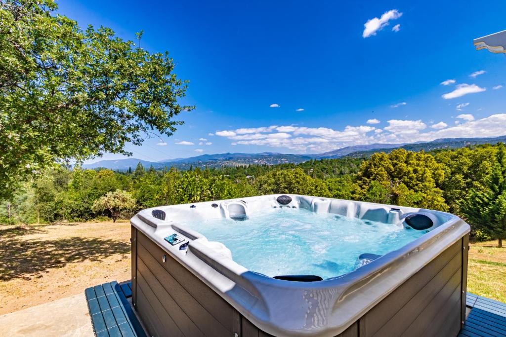 a hot tub with a view of the mountains at Spectacular Views w/ Hot Tub/BBQ -Yosemite & Bass Lake in Oakhurst