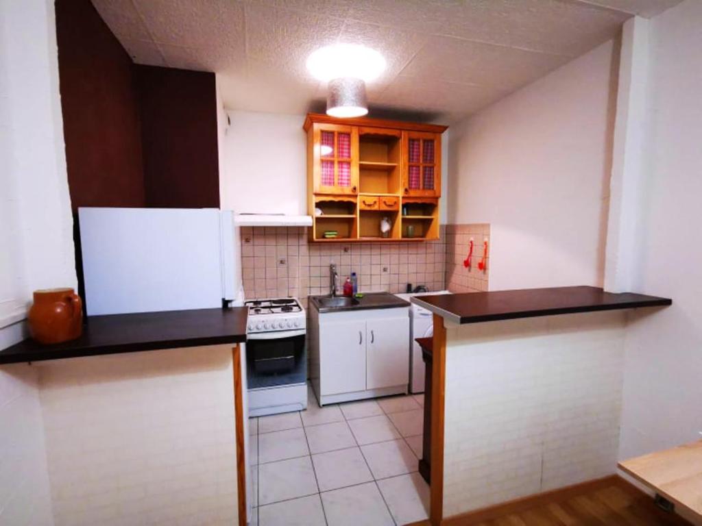 a small kitchen with white appliances and brown cabinets at Appartement de 2 chambres avec vue sur la ville et wifi a Clermont Ferrand in Clermont-Ferrand