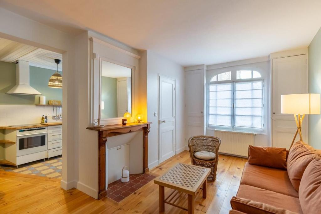 een woonkamer met een bank en een tafel bij La maison d'à côté 3 - 6 people - 3 bedrooms - 2 bathrooms in Honfleur