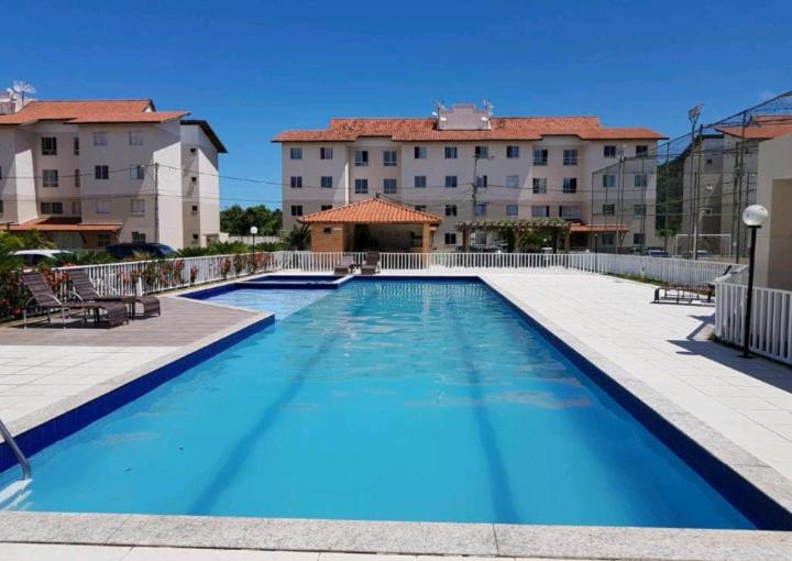 una grande piscina blu di fronte ad alcuni edifici di Vog João de Góes a Ilhéus