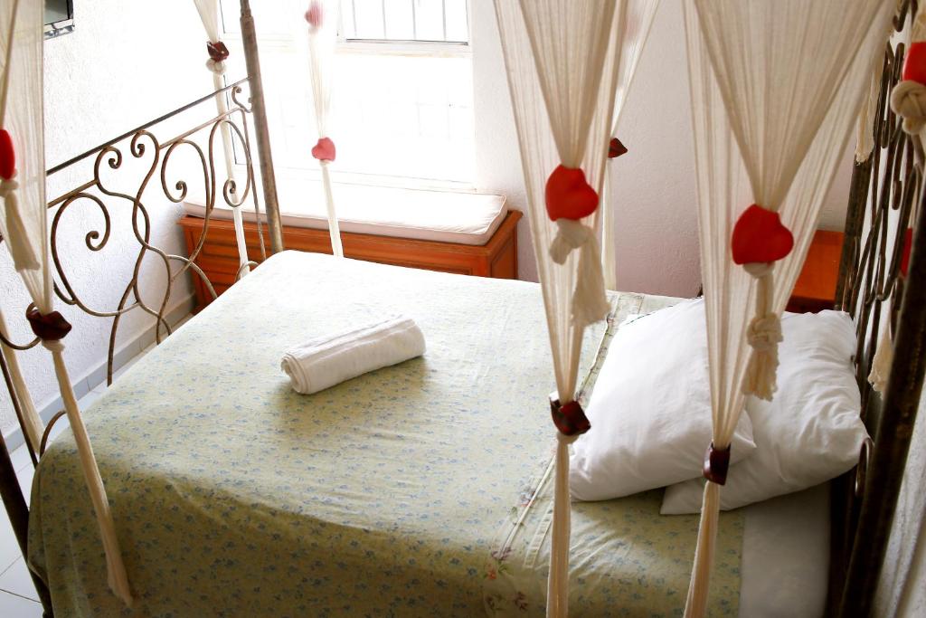a bedroom with a bed with red flowers on it at Habitación Privada, Jacuzzi Rooftop, AC, GRAN Wifi in Cancún