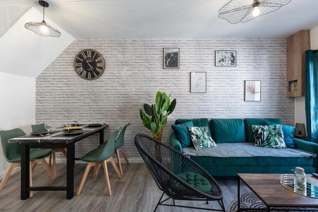 uma sala de estar com um sofá azul e uma mesa em Vert d'Hotes - Charming renovated apartment - downtown - WIFI - em Honfleur
