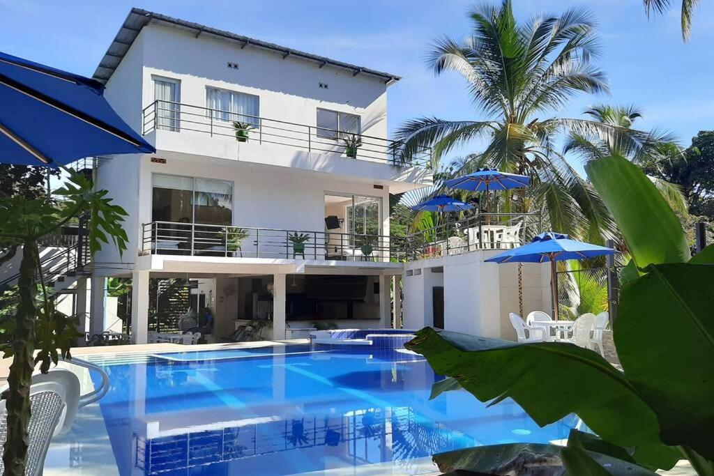a villa with a swimming pool in front of a house at CASA VACACIONAL CAMPOSOL in Melgar