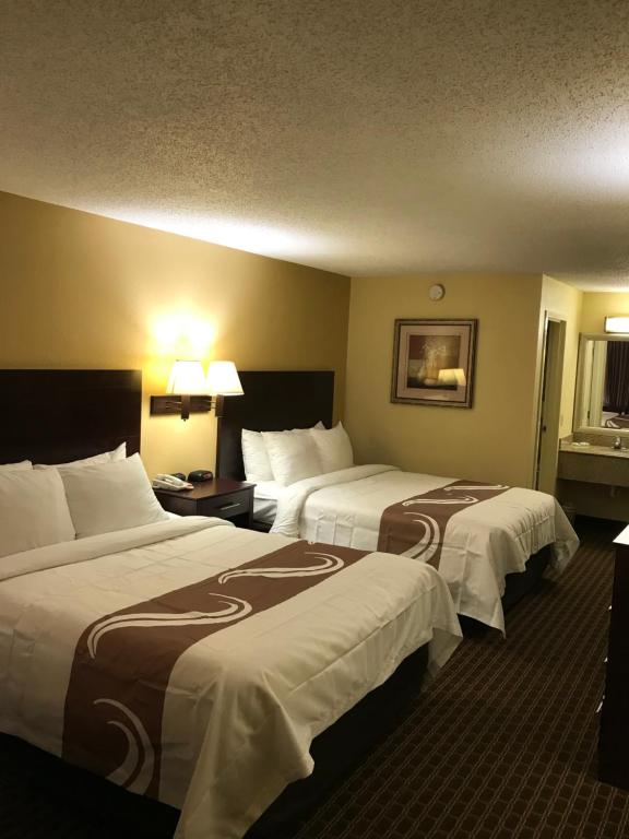 a hotel room with two beds with white sheets at Quality Inn in Franklin