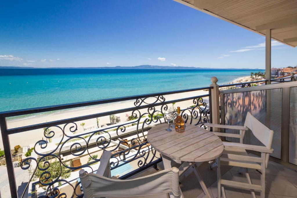 a balcony with a table and chairs and the ocean at Alkionides Rooms in Polykhrono