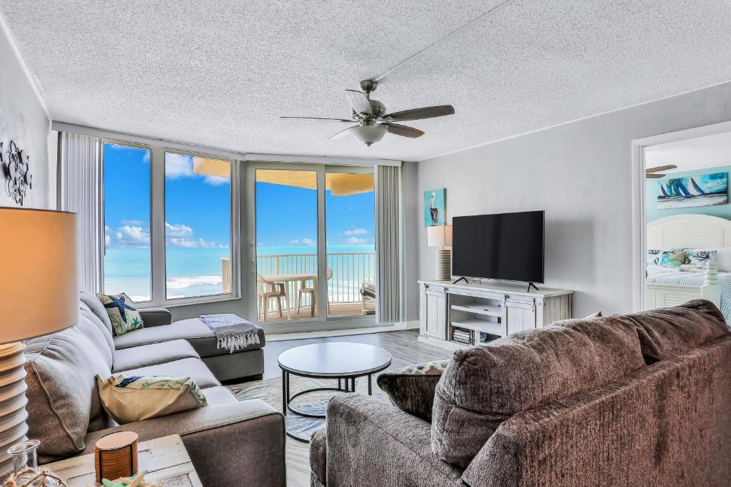 a living room with a couch and a flat screen tv at Top Floor at the Shores in Daytona Beach Shores