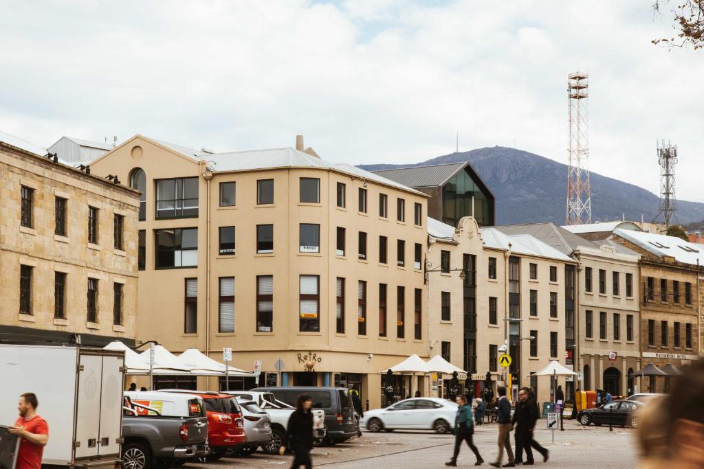 um grupo de pessoas andando por uma rua da cidade com edifícios em Salamanca Galleria Apartments em Hobart