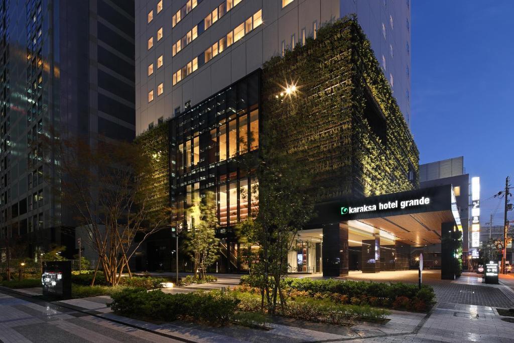 a building in a city at night at karaksa hotel grande Shin-Osaka Tower in Osaka