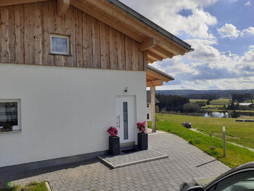 uma casa branca com flores à frente em Ferienhaus Herbstzauber em Haidmühle