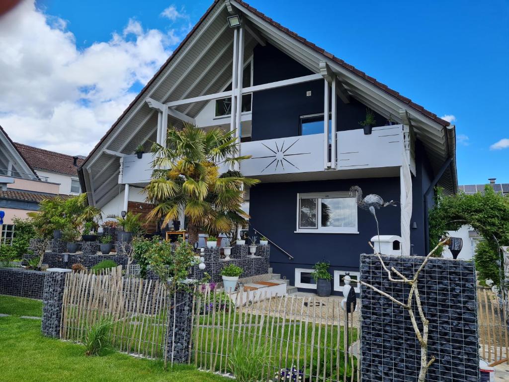 una casa azul y blanca con una valla en Adonde, en Neuried