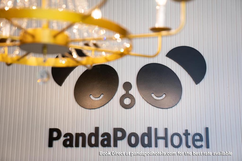 a sign for a panda pod hotel with a chandelier at Panda Pod Hotel in Richmond