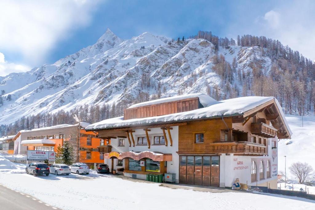un edificio con una montagna innevata sullo sfondo di Arina Apartments a Samnaun