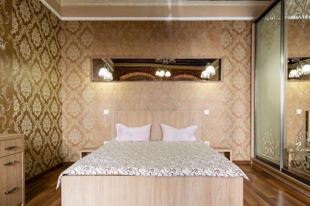 1 dormitorio con 1 cama grande con almohadas rosas en Spirit of old Lviv apartment main square, en Leópolis