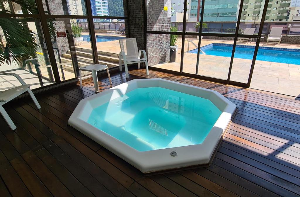 a jacuzzi tub on a deck with a pool at Costa Sul Beach Hotel in Balneário Camboriú