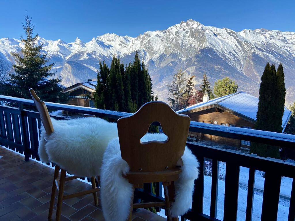 a chair on a balcony with a view of mountains at Chalet Belle Poncke in Nendaz