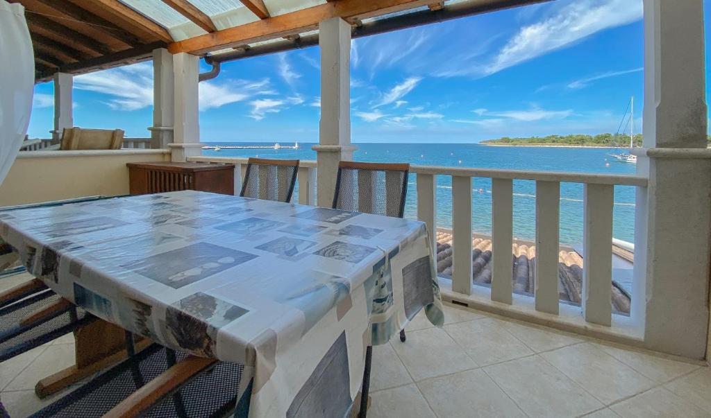 einen Balkon mit einem Tisch und Meerblick in der Unterkunft Apartment Laura in Novigrad Istria