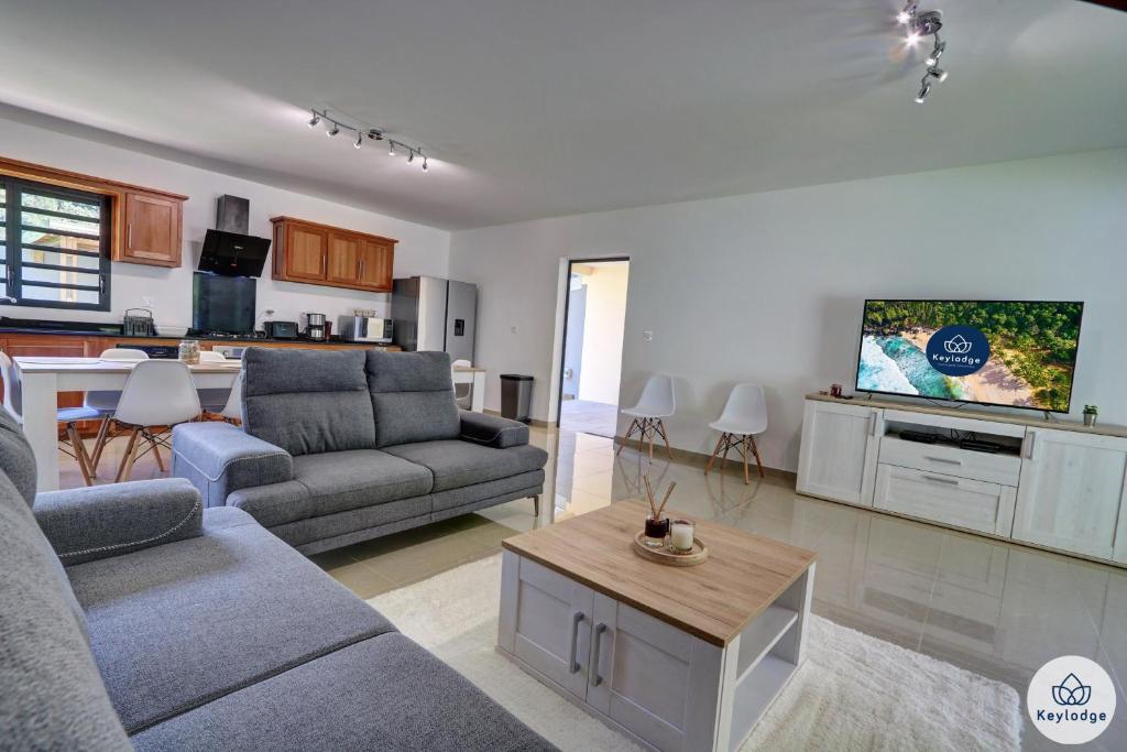 uma sala de estar com um sofá e uma mesa em Villa Embellia 3 étoiles, 147 m2 pour un séjour nature à Salazie em Salazie